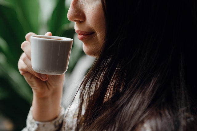 wpływ kawy na cerę - kobieta z kawą