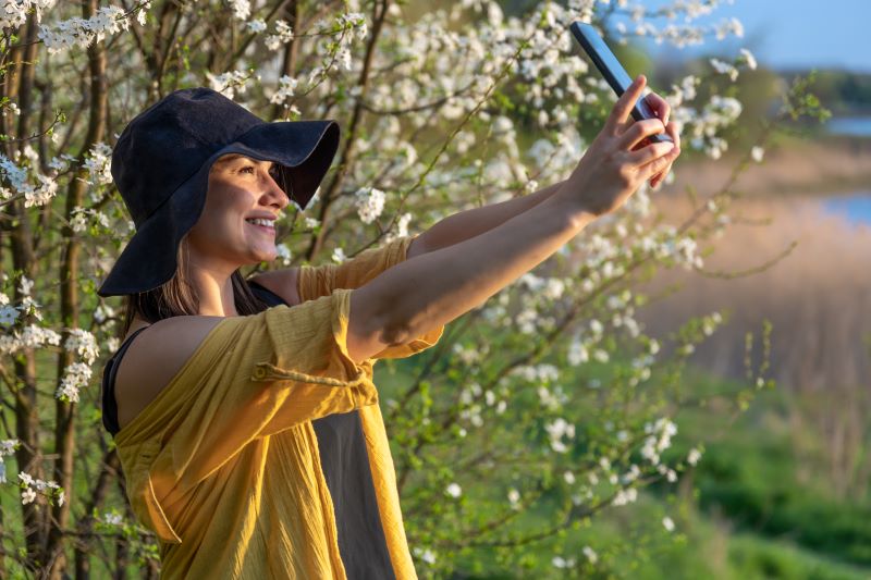 kobieta robiąca selfie wśród krzewów